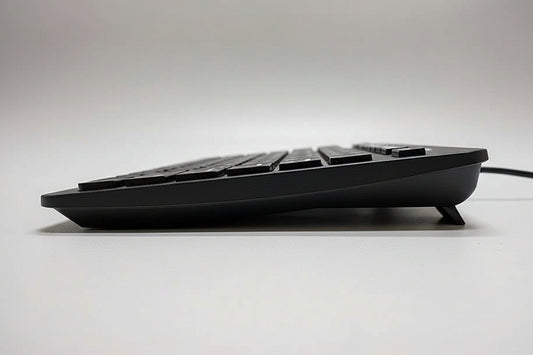Black keyboard on a white surface with a blurred background